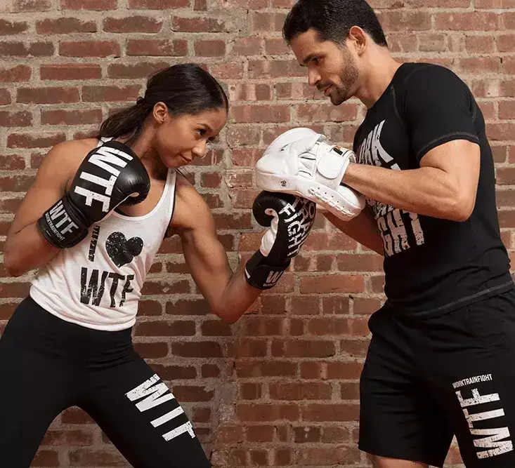 Boxing trainer teaching giving lessons to a young trainee boxing and strength training